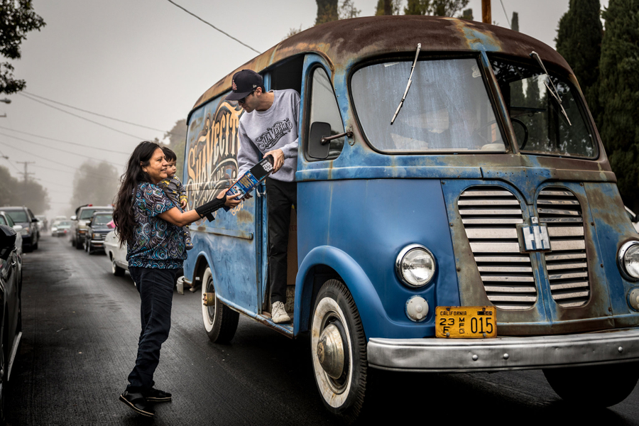Tony handing out Christmas gifts from the Suavecito Metro Van